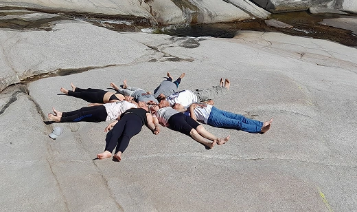 Grupo de personas acostadas formando una estrella, meditando.